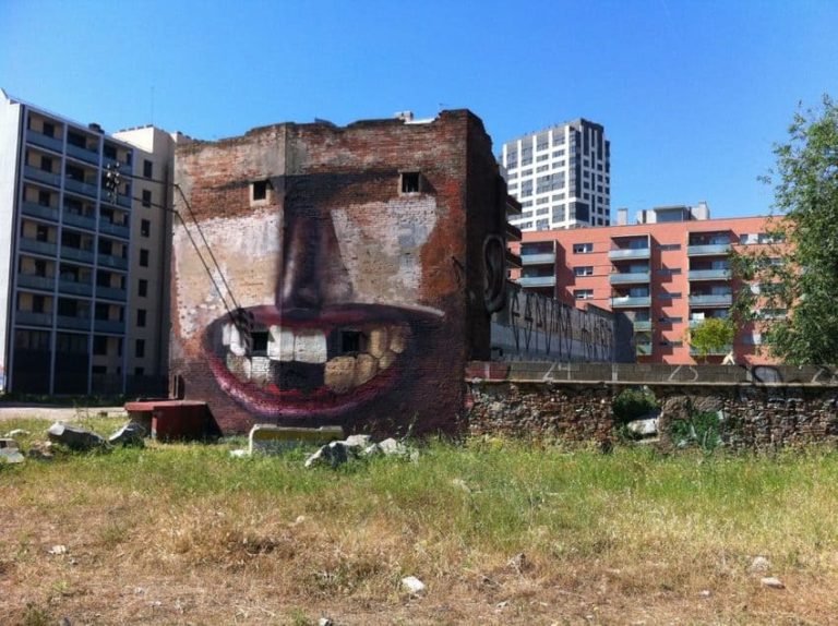 Façana pintada com una cara somrient gegant, Penao art públic, edifici en ruïnes, Rebobinart 2014