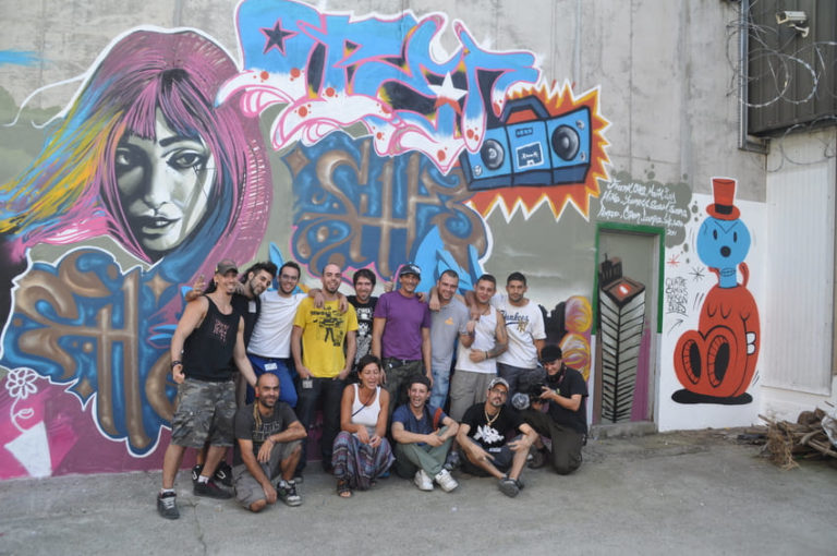 Quatre Camins: sis artistes i vuit interns pintant el mur d'una presó.