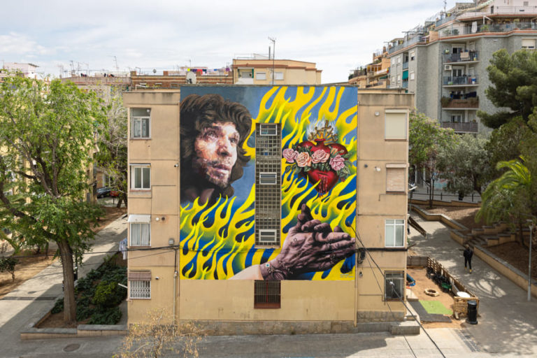 Mural con un retrato entre llamas amarillas y un corazón con rosas, l'Uriginal Cultura Popular, L'Hospitalet, Rebobinart