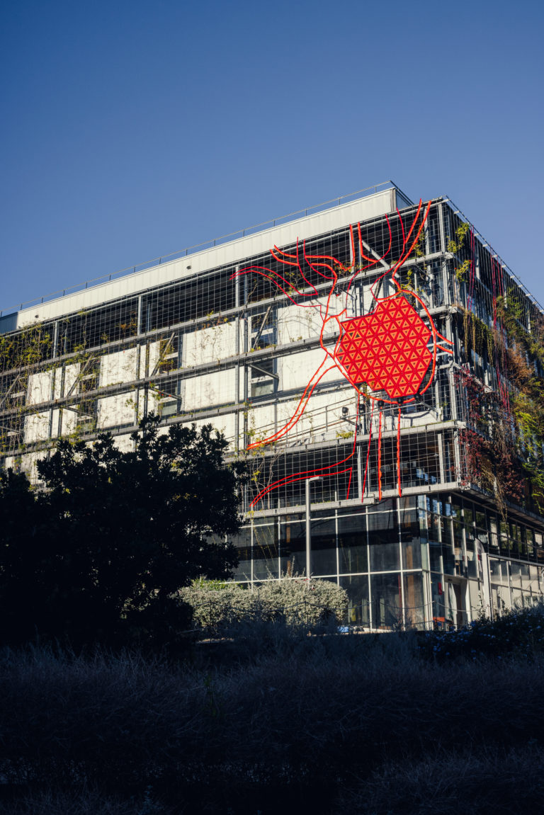 Escultura de un corazón rojo con arterias en la fachada de un edificio, Basurama Cor, Barcelona, Rebobinart