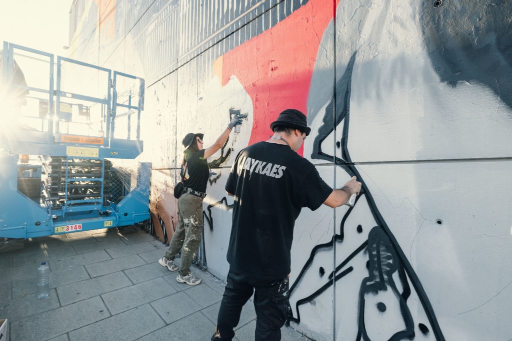 Mural Força Plural – Jay Kaes_2 Arte público Jay Kaes Fuerza Plural, clavel rojo identidad obrera, mural exterior Nou Barris