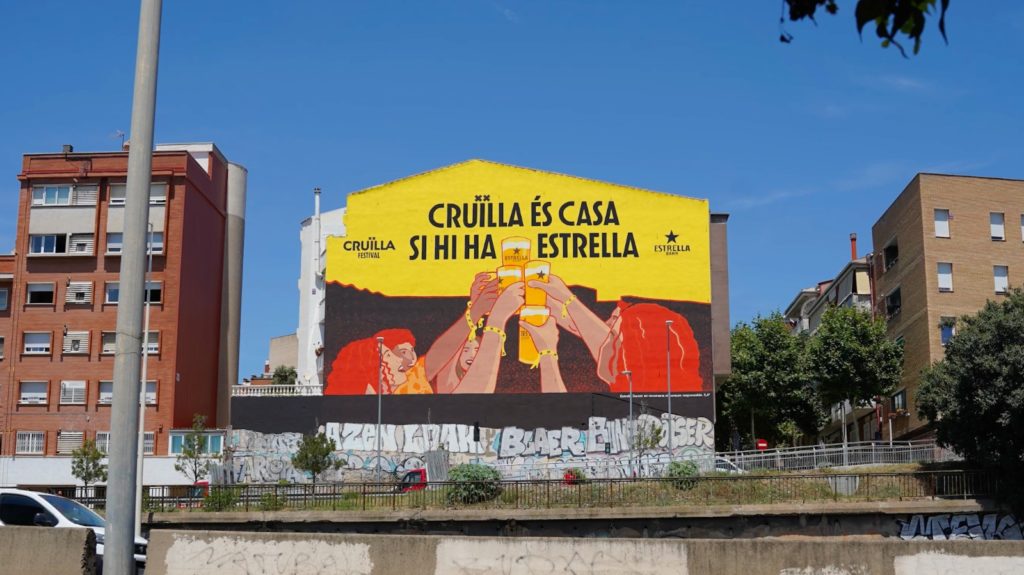 Mural publicitario Cruïlla Festival y Estrella Damm, gran formato C-31 Badalona, mural encargo empresa, Rebobinart 2026