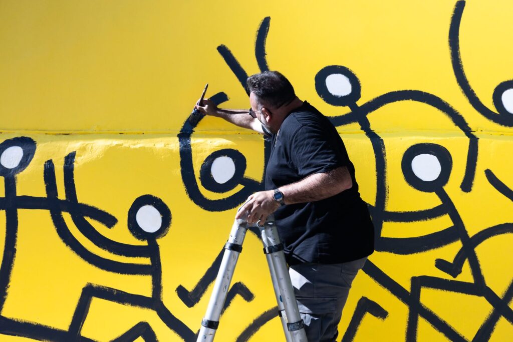 Javirroyo omple de blanc els caps dels personatges, de prop, mural CASA NOSTRA, Barcelona, Rebobinart 2026