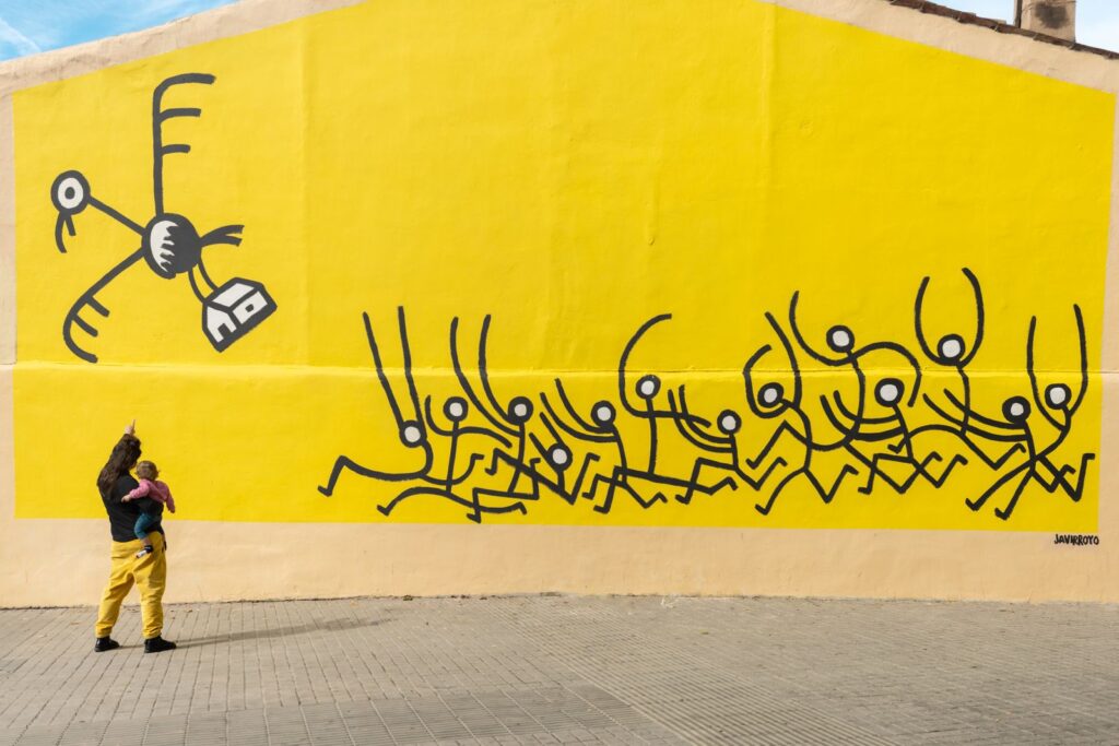 El mural sencer amb el voltor que s'emporta la casa i la gent que el persegueix, art urbà sobre l'habitatge, CASA NOSTRA, Barcelona, Rebobinart 2026