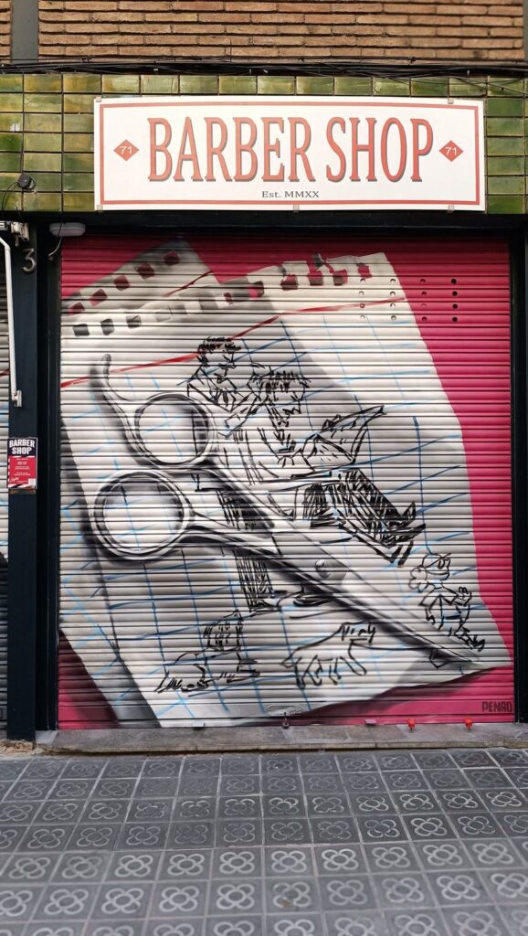 Persiana barber shop — Penao, Les Corts Persiana de la Barber Shop pintada per Penao amb unes tisores de barber realistes sobre un full de quadern ple d'esbossos de personatges dibuixats a mà, sobre fons vermell — Persianes que fan barri, Les Corts, Barcelona, Rebobinart 2026