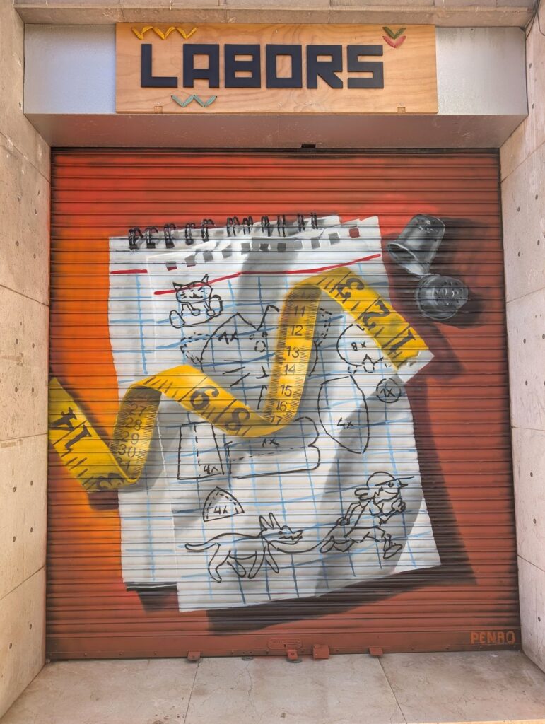 Persiana fent punt — Penao, Les Corts Persiana de Fent Punt pintada per Penao amb una cinta mètrica groga i un didal realistes sobre un full de quadern amb animals i personatges dibuixats a mà, sobre fons taronja — Persianes que fan barri, Les Corts, Barcelona, Rebobinart 2026
