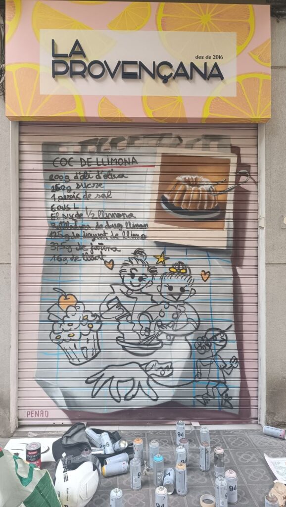 Persiana pastisseria la provencana — Penao, Les Corts Persiana de la Pastisseria La Provençana pintada per Penao amb la recepta escrita a mà del coc de llimona, la foto d'un coc i pastissets dibuixats amb cara sobre un full de quadern — Persianes que fan barri, Les Corts, Barcelona, Rebobinart 2026